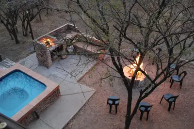 an overhead view of a pool with chairs and a fireplace at Umvangazi Rest in Marloth Park