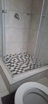a bathroom with a shower and a toilet at Magoveni Accommodation