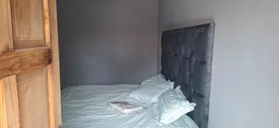 a bedroom with a bed with a wooden headboard at Magoveni Accommodation