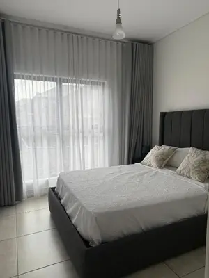 a bedroom with a bed and a large window at AAAA Property Management in Midrand