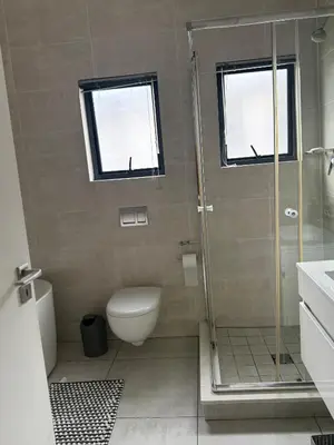 a bathroom with a toilet and a glass shower at AAAA Property Management in Midrand