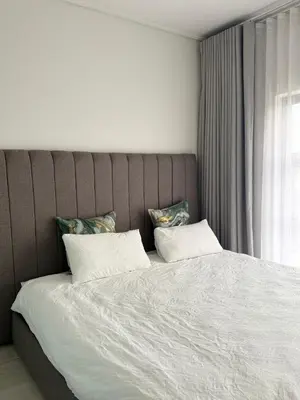 a bedroom with a large bed with white sheets and pillows at AAAA Property Management in Midrand