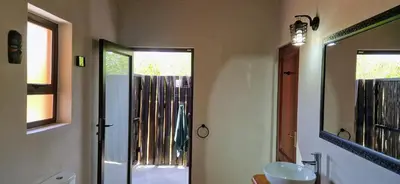 a bathroom with a sink and a mirror at Phumula Bushvilla in Phalaborwa