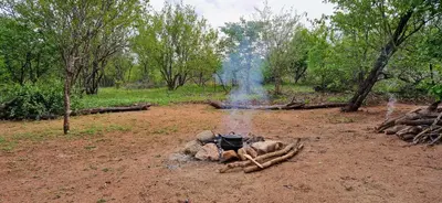 a fire pit in the middle of a dirt field at Phumula Bushvilla in Phalaborwa