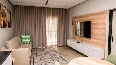 a living room with a couch and a tv at Villa On 59 in Giyani