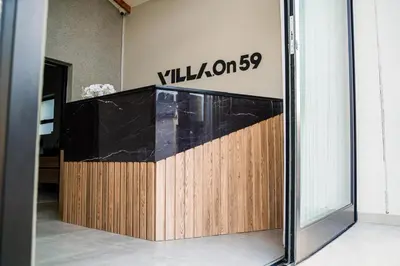 a lobby with a counter with a sign on the wall at Villa On 59 in Giyani
