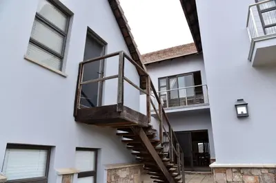 a stairwell in the side of a white building at Highlands Retreat Loft Unit in Highland Gate Golf and Trout 1135 in Dullstroom