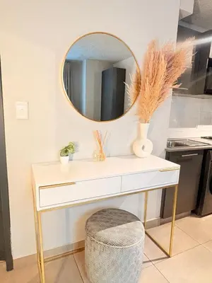 a dressing table with a mirror and a stool at Unit 87 at Circa Lynwood in Pretoria