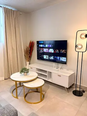 a living room with a tv and a coffee table at Unit 87 at Circa Lynwood in Pretoria