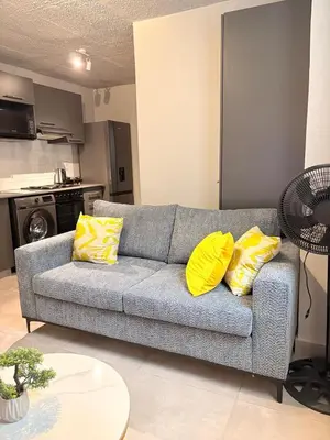 a living room with a couch with yellow pillows at Unit 87 at Circa Lynwood in Pretoria