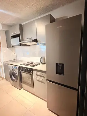 a kitchen with a stainless steel refrigerator and a stove at Unit 87 at Circa Lynwood in Pretoria