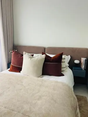 a bed with a bunch of pillows on it at The Blyde Luxury Apartment in Pretoria