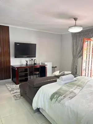 a bedroom with a bed and a desk and a television at 14 Isabel in Centurion