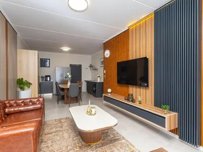 a living room with a couch and a tv at Woodland Haven in Midrand