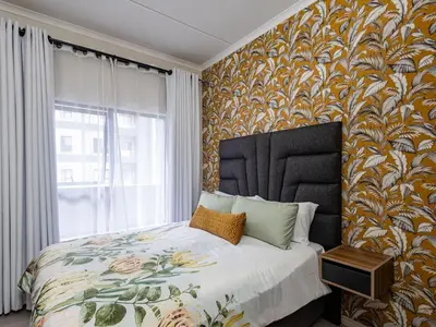 a bedroom with a large bed with a large window at Woodland Haven in Midrand