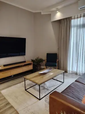 a living room with a tv and a coffee table at Menlyn Maine Trilogy Apartment 1220 & 1221 in Pretoria
