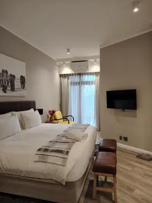 a bedroom with a large bed and a flat screen tv at Menlyn Maine Trilogy Apartment 1220 & 1221 in Pretoria