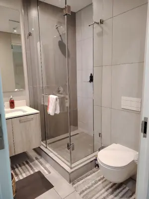 a bathroom with a shower and a toilet and a sink at Menlyn Maine Trilogy Apartment 1220 & 1221 in Pretoria