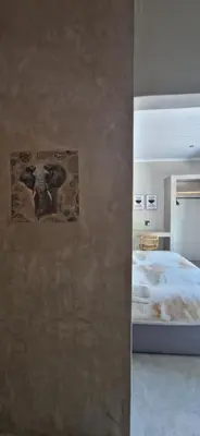 a bedroom with a bed and a painting on the wall at Krek Wak Wou Bush Villa in Marloth Park
