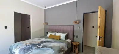 a bedroom with a large bed with a earth themed comforter at Krek Wak Wou Bush Villa in Marloth Park
