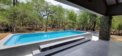 a swimming pool in the middle of a house at Krek Wak Wou Bush Villa in Marloth Park