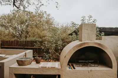 a stone pizza oven in a backyard with a table at WildlifeEstateVilla-Pool-Boma-Bushlife in Hoedspruit