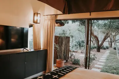 a bedroom with a bed and a large window at WildlifeEstateVilla-Pool-Boma-Bushlife in Hoedspruit