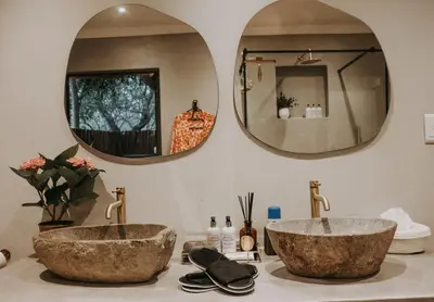 two sinks on a bathroom counter with two mirrors at WildlifeEstateVilla-Pool-Boma-Bushlife in Hoedspruit