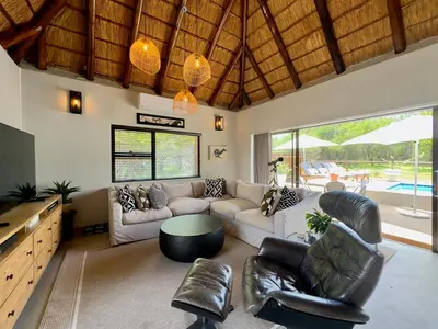 a living room with a couch and a table at WildlifeEstateVilla-Pool-Boma-Bushlife in Hoedspruit