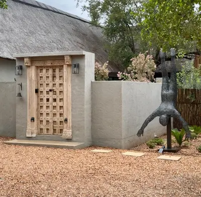 a statue next to a building with a door at WildlifeEstateVilla-Pool-Boma-Bushlife in Hoedspruit