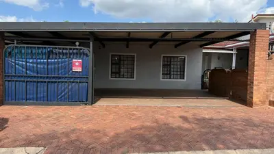 a garage with a blue gate in front of a house at Entire Premises ideal for large groups and reunions in Pretoria