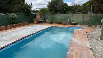 a swimming pool with blue water in a backyard at Entire Premises ideal for large groups and reunions in Pretoria