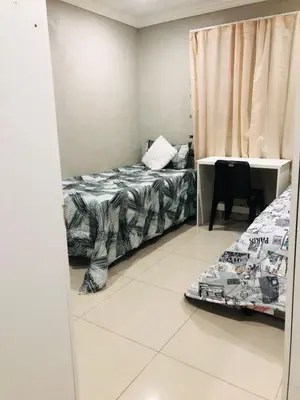 a bedroom with two beds and a table and a mirror at Entire Premises ideal for large groups and reunions in Pretoria