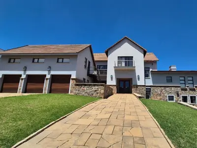 a large white house with a brick driveway at Deluxe Suite at in Highland Gate Golf and Trout Estate 1135 in Dullstroom