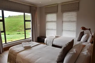 a bedroom with two beds and a large window at Deluxe Suite at in Highland Gate Golf and Trout Estate 1135 in Dullstroom