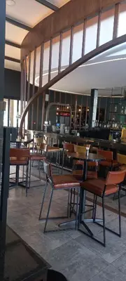 a restaurant with tables and chairs and a bar at Waterfall Midrand in Northdene