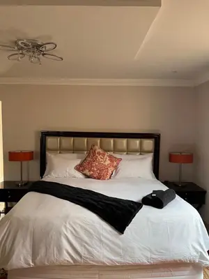 a bedroom with a large white bed with two lamps at MorningMist Boutique 27 Dawie de Villiers Room 3 in Centurion