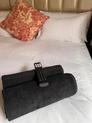 a remote control sitting on top of a bed at MorningMist Boutique 27 Dawie de Villiers Room 3 in Centurion