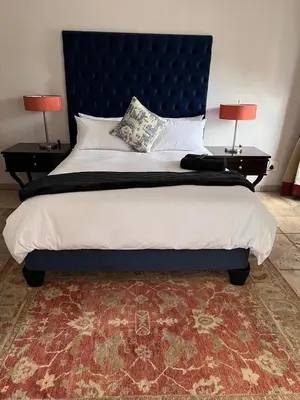 a large bed with a blue headboard and two lamps at MorningMist Boutique 27 Dawie de Villiers Room 2 in Centurion