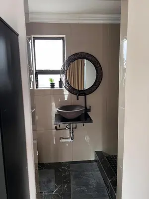 a bathroom with a sink and a mirror on the wall at MorningMist Boutique 27 Dawie de Villiers Room 2 in Centurion