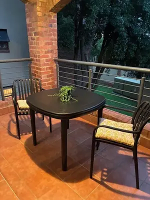 a black table and two chairs on a patio at Apartment of Convenience-In the heart of Midrand in Midrand
