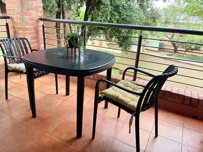a black table and chairs on a balcony at Apartment of Convenience-In the heart of Midrand in Midrand
