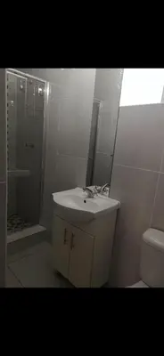a bathroom with a sink and a shower and a toilet at Soteria House in Kempton Park