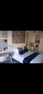 a bedroom with a large bed and a table at Soteria House in Kempton Park