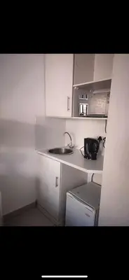 a small white kitchen with a sink and a microwave at Soteria House in Kempton Park