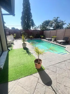 a swimming pool with two potted plants in a yard at 17 Byvanger Luxury Room 6 in Centurion