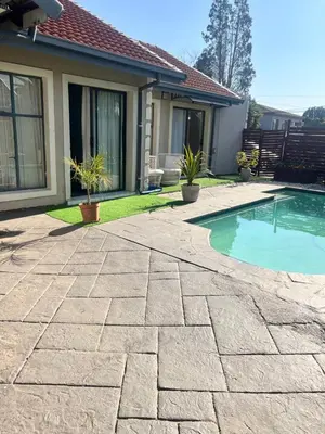 a backyard with a swimming pool and a house at 17 Byvanger Luxury Room 6 in Centurion