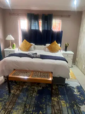 a bedroom with a large bed with a blue headboard at 17 Byvanger Luxury Room 6 in Centurion