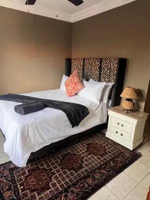 a bedroom with a bed with white sheets and pillows at MorningMist Boutique 27 Room 5 in Centurion