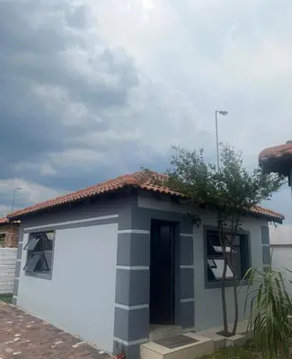 a small house with a large white garage at MorningMist Boutique 27 Room 5 in Centurion